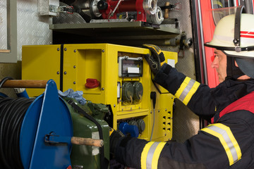 Fototapeta premium Feuerwehrmann im Einsatz am Stromgenerator