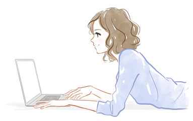 寝転がってパソコンを操作する女性