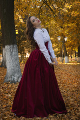 Fototapeta premium Woman dressed in a retro-style on the autumn alley