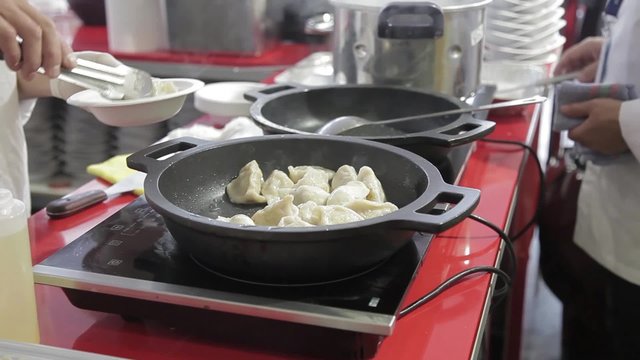 Cocinero preparando Gyoza, empanadillas tailandesas

