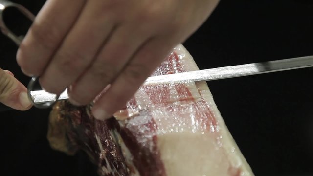 Un cocinero corta jamon iberico 
