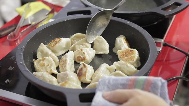 Cocinero preparando Gyoza, empanadillas tailandesas

