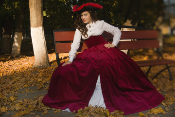 Fototapeta premium Woman dressed in a retro-style on the autumn alley
