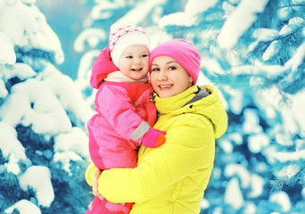 Fototapeta premium Happy smiling mother and child having fun together in snowy wint