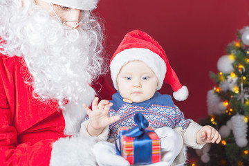 Happy baby and Santa Claus with big gift, present box