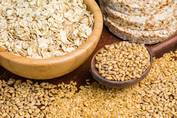 Variety of grains: rolled oats, golden linseeds (flax seeds), whole wheat grains and buckwheat cakes. Soft focus
