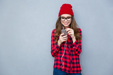 Smiling woman using smartphone with headphones