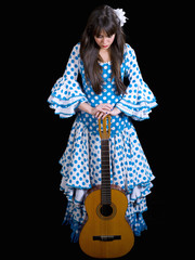 Young woman with a Spanish guitar, flamenco dress