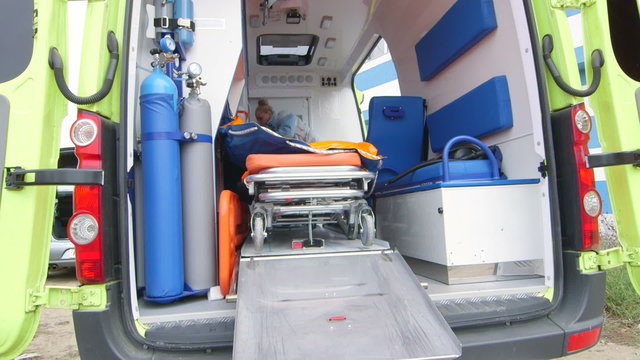 Emergency medical service female paramedic working in opened ambulance