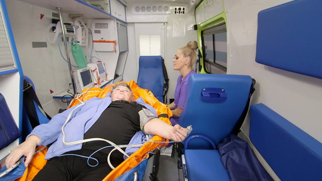 Paramedic provide basic emergency medical care and transportation for critical senior patient in ambulance