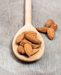 Fine almonds on wooden spoon
