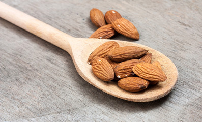 Fine almonds on wooden spoon