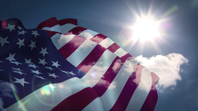 American flag blowing against blue sky