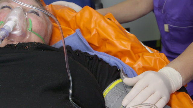 Senior person receiving advanced emergency medical care in ambulance