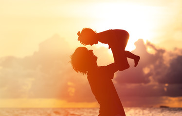 Father and little daughter silhouettes at sunset