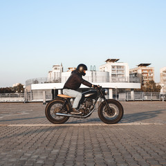 Motorcyclist riding on a motorcycle in parking lot in city