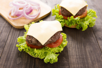 Cheeseburgers on buns with succulent beef on the wooden table