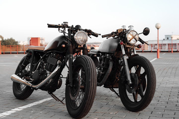 Fototapeta na wymiar Two vintage motorcycle in parking lot during sunset