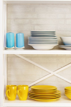 blue and yellow plates and a candle on a white shelf