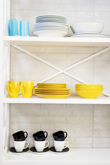 blue and yellow plates and a candle on a white shelf