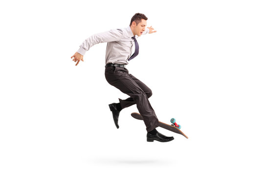 Skillful businessman performing trick on skateboard