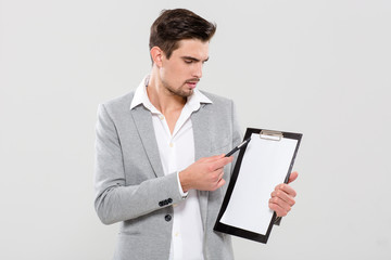 Handsome man pointing on clipboard