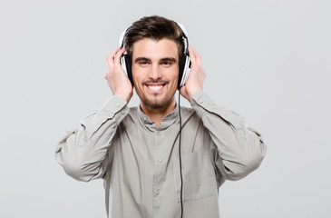 Happy cheerful young man listening to music