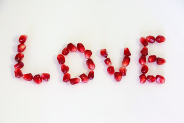 Inscription love. Letters from berries pomegranate.