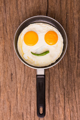 Smiley egg with chilly on a pan
