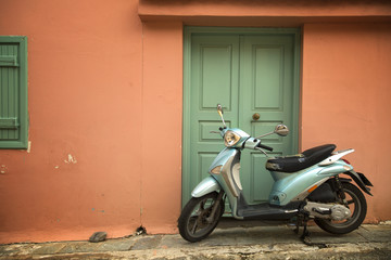 Blue scooter on a peach wall
