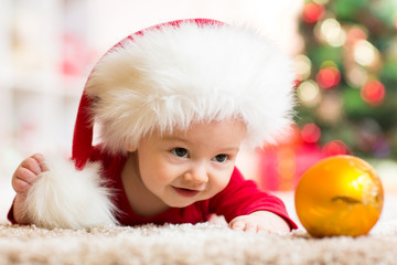 Obraz na płótnie Canvas Funny baby in Santa Claus clothes with xmas tree