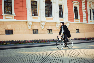 Fototapeta premium young caucasian businessman riding bicycle