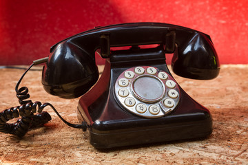 Old telephone on wood background.