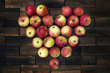 Heart of apples on old wooden background. Grunge style. Delicious fruit. Image of natural materials.