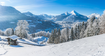 Idyllic snowy winter landscape in the Alps with traditional mountain chalet