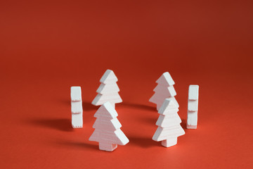 White christmas trees made of wood placed placed in a circle on a red background.