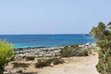 View of Cala Mitjana in Menorca during a summer day with blue sky a transparent water, Balearic Islands, Spain