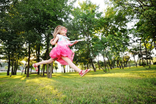 baby girl jumping with a toy guitar