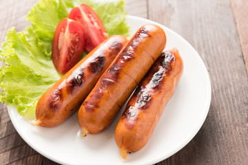 sausages laid on lettuce with tomato slices