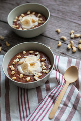 Chocolate cereal with bananas and nuts on the table with a wooden spoon