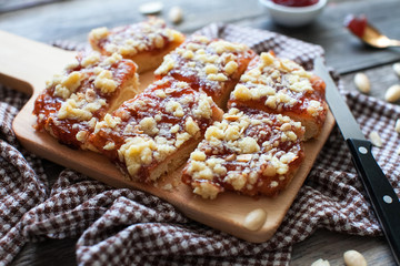 chopped shortbread with jam and cashew nuts on a board and a napkin