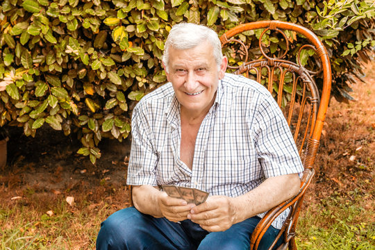 octogenarian elder play cards in the garden