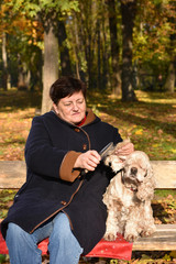 Senior woman sitting on a bench with a dog
