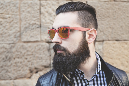  Closeup of a modern young man with red sunglasses. Hipster