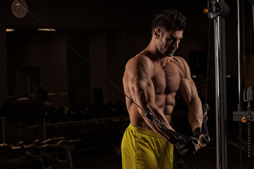 Fototapeta na wymiar Young adult bodybuilder doing weight lifting in gym.