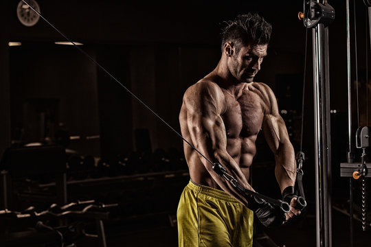 Young adult bodybuilder doing weight lifting in gym.