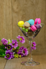 colorful macaroons in glass on wooden table
