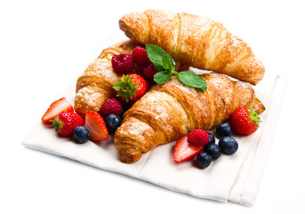 Fresh tasty croissants with berries on white background