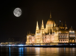 Obraz premium Night scene of the famous Parliament building and full moon on the sky in Budapest, Hungary