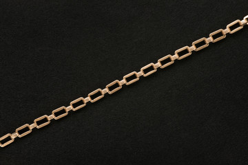 Fototapeta na wymiar Golden chain on black felt background